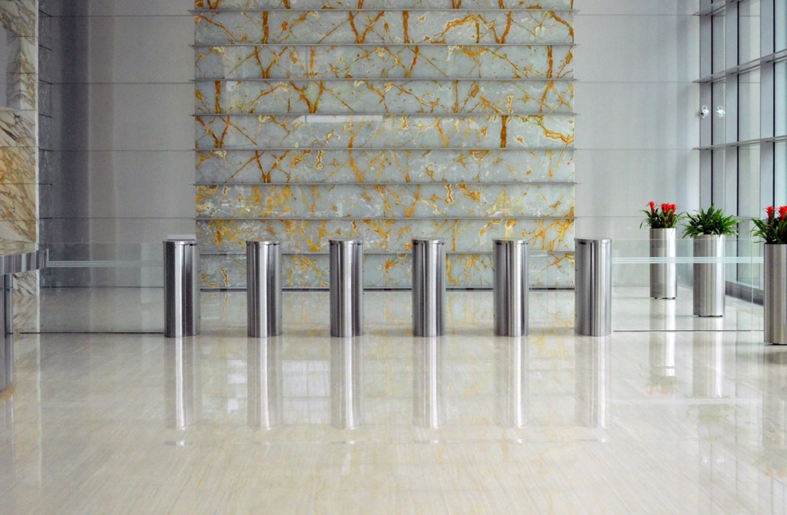 An office building foyer with security gates and a marble wall